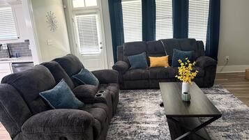 Una sala de estar con un sofá modular, una mesa de centro y un florero con flores.