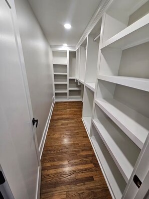 A narrow hallway with wooden flooring and white shelving units. - 10 mins from Mercedes Benz stadium! (Atlanta)