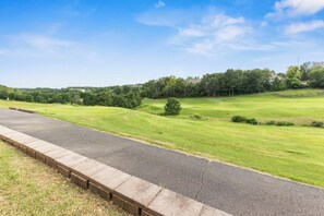 A paved road with a grassy area and trees in the background. - THO2-2, Moose Creek 2BR Condo with Golf Views at Thousand Hills (Branson)