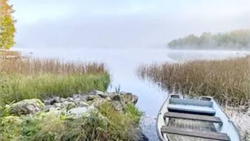 A boat on a narrow waterway surrounded by vegetation.