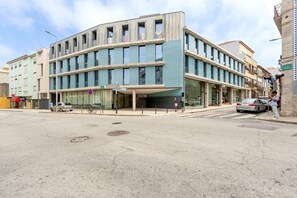 Ein modernes Gebäude mit einer gewölbten Fassade, großen Fenstern und einem überdachten Eingang.