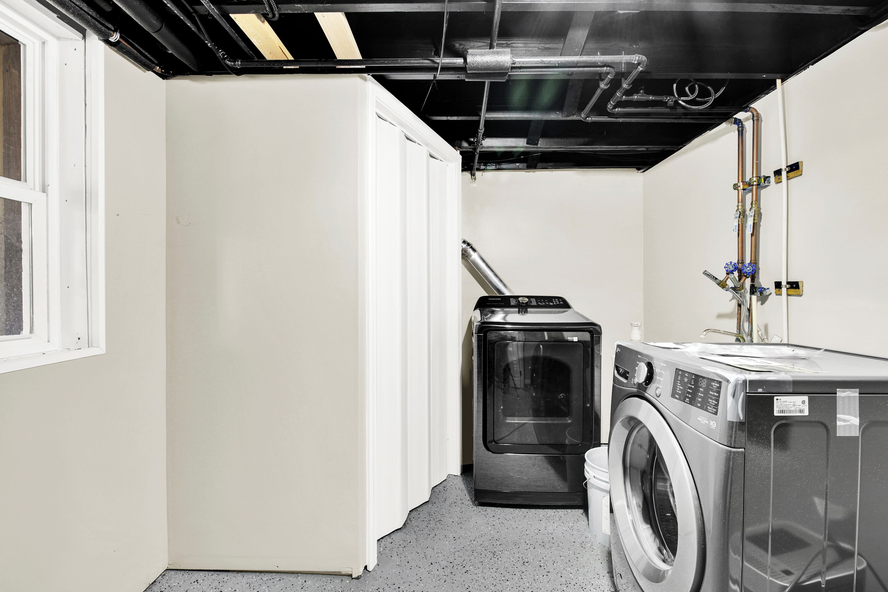 Une buanderie équipée d’un lave-linge, d’un sèche-linge et d’un chauffe-eau.