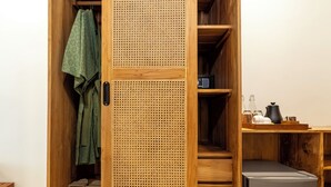 Une armoire en bois avec un panneau en rotin, une serviette verte et une paire de sandales.