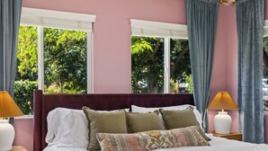 A bedroom with a large bed, two bedside tables, a window with curtains, and a ceiling with a patterned design. - Movie Theater • Tennis • Barrel Sauna • Hot Tub (Templeton)