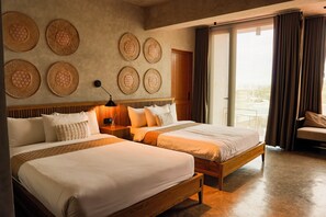 A hotel room with two beds, a wooden headboard, a nightstand, a lamp, and a view of the outdoors through a window with curtains. - The Salt Boutique Hotel by Wyns (San Fernando)