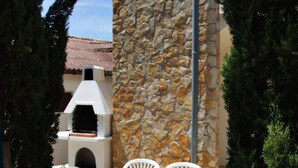 A stone wall, a white outdoor oven, and white chairs. - Apartments by Seni (Kolan)