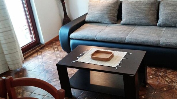 A living room with a sofa, a small table, and a chair. - Apartments by Seni (Kolan)