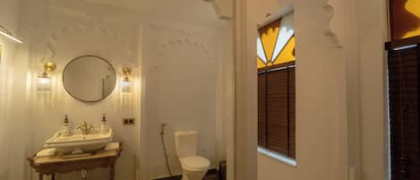 Un baño con lavamanos, espejo e inodoro.