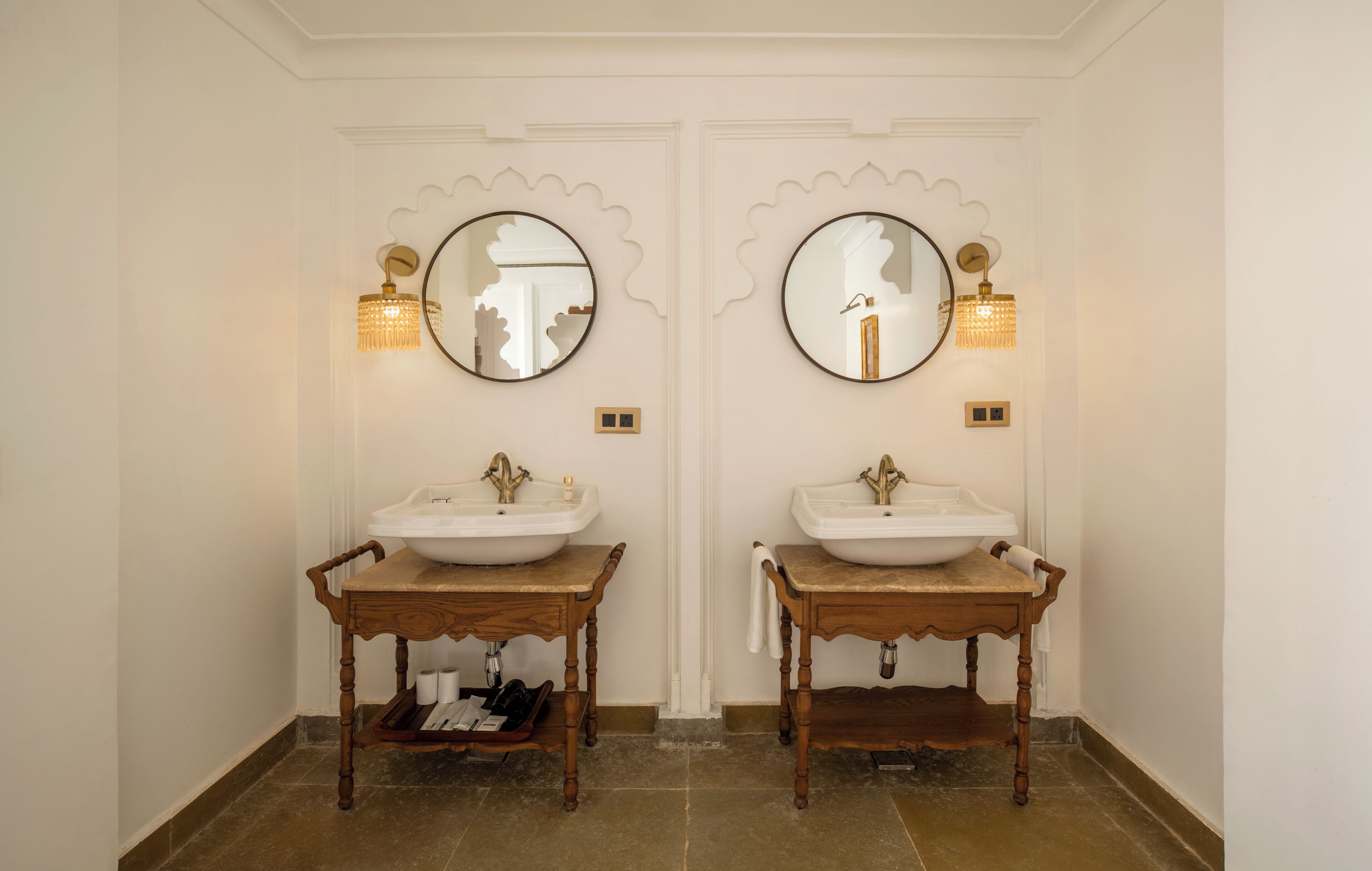 A bathroom with two sinks, each with a mirror and wall-mounted light fixture.