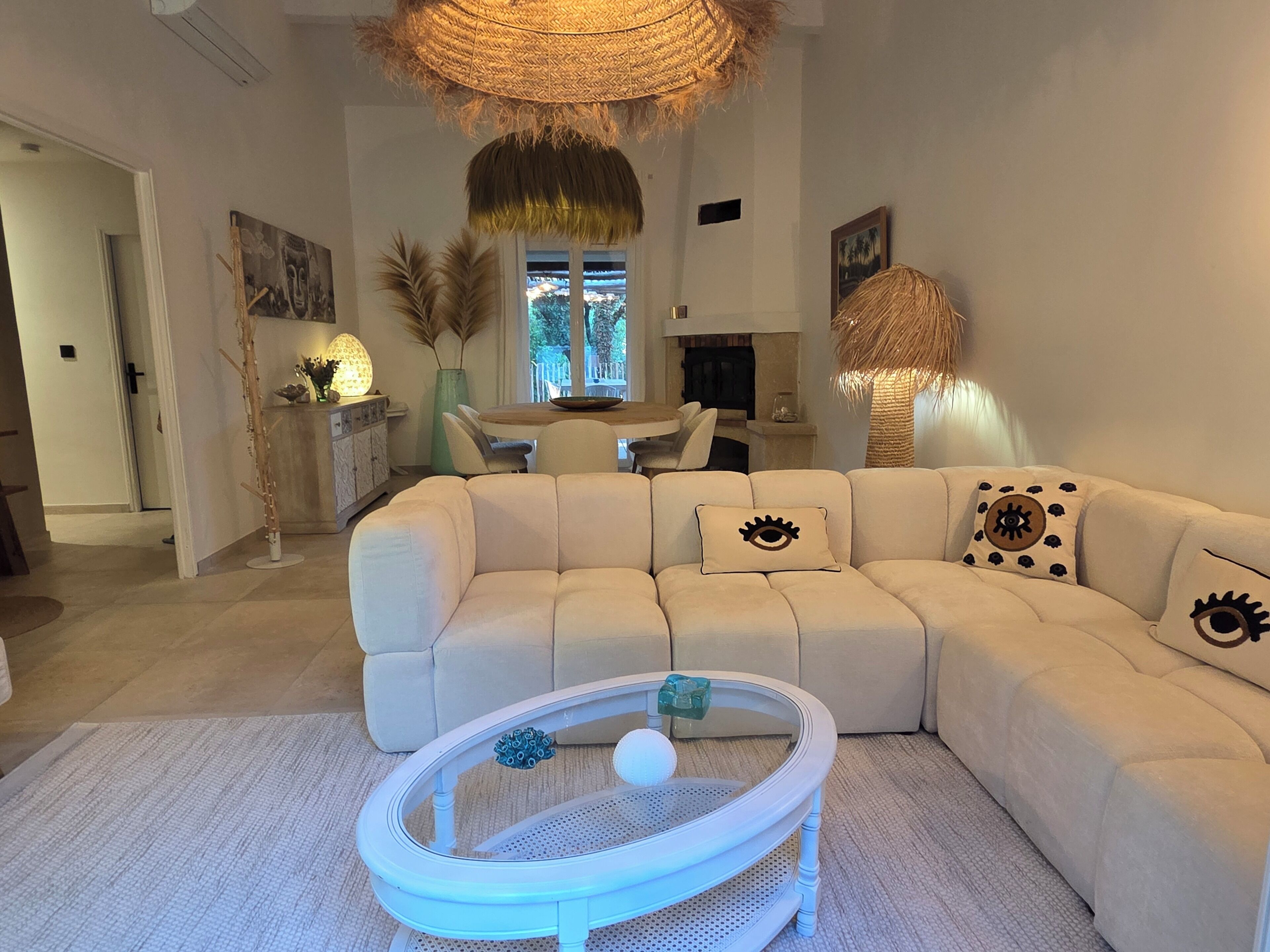 A modern living room with a sectional sofa, a round coffee table, and a dining area with a table and chairs.