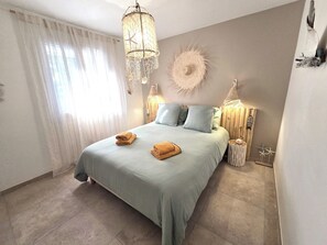 Ein Schlafzimmer mit einem Bett, zwei Nachttischlampen, einer Wanduhr und einem Wanddekor.