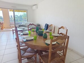 A dining area with a round table, chairs, and various tableware. - Le Grand Parc by Interhome (Saint Aygulf)