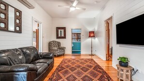 A living room with a leather sofa, patterned armchair, and a patterned rug.
