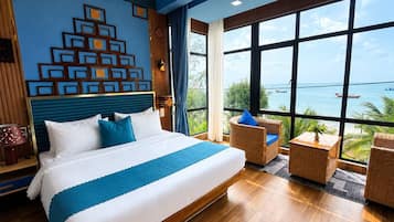 Habitación de hotel con una cama grande, vista al mar y una pared decorativa.