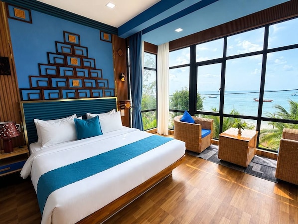 Habitación de hotel con una cama grande, vista al mar y una pared decorativa.