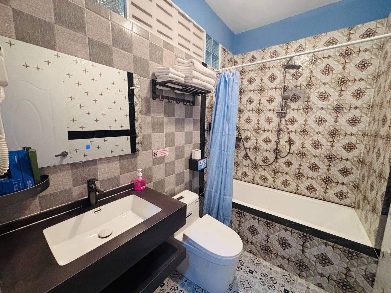 Un baño con lavamanos, inodoro y ducha.