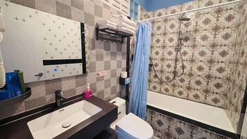 Un baño con lavamanos, inodoro y ducha.
