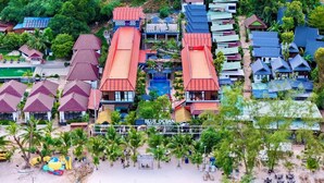 Un complejo turístico con varias edificaciones, piscina y zona de playa.