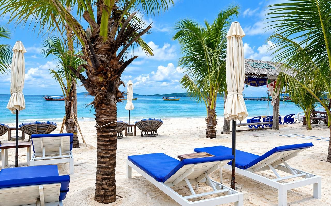 A beach with lounge chairs, umbrellas, and a boat in the background.