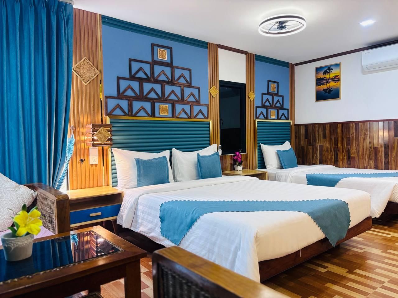 A hotel room with two beds, a wooden headboard, a mirror, and a wall with geometric patterns.