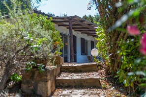 A rustic house with a wooden porch, stone steps, and a satellite dish. - Vista Sull'Enfola - Goelba (Portoferraio)