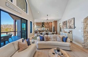 Ein geräumiges Wohnzimmer mit einer großen Couch, einem Couchtisch und Blick auf den See.