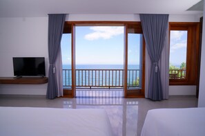 A hotel room with a large balcony, a television, and a bed. - Blue Haven Resort Quy Nhon (Xuan Loc)