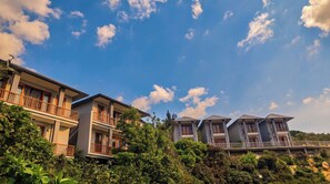 A hotel with multiple-story buildings, balconies, and lush greenery.