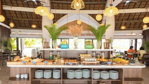 A buffet setup with various food items and a central decorative plant arrangement.