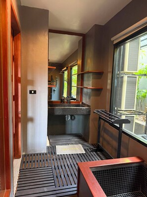 A narrow hallway with a black metal grate floor, a window with a metal screen, and a tiled backsplash in the background. - Maan Tawan Front Beach Villa 12 (Choeng Thale)
