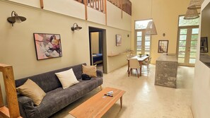 A spacious living area with a sofa, a dining table, and a kitchen area. - Casco Viejo Apartment (Panamá)