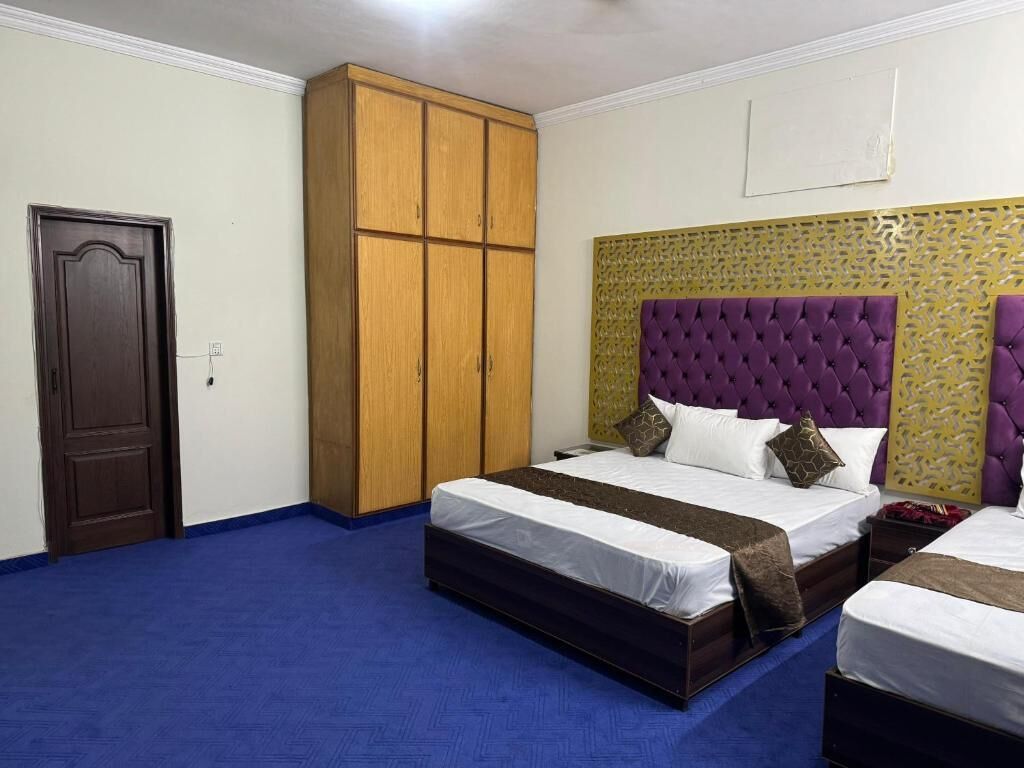 A bedroom with a large bed, a wardrobe, and a door.