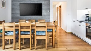 Moderni keittiö, jossa on valkoiset kaapit, sisäänrakennettu uuni ja kahvinkeitin.