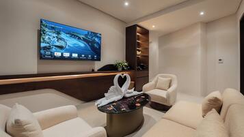 Deluxe Suite | Living area | 48-inch flat-screen TV with digital channels