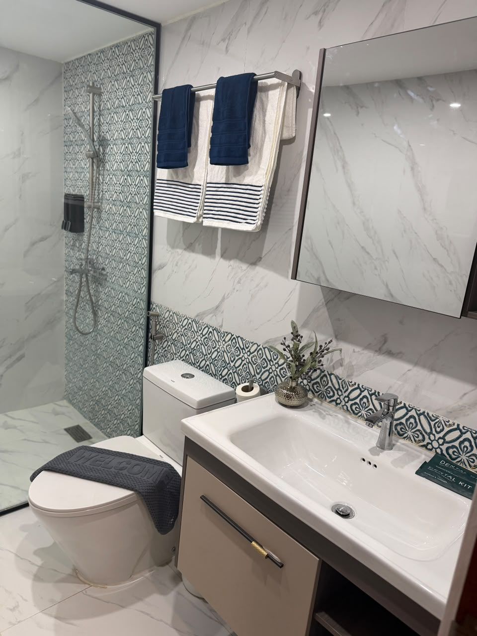 Een moderne badkamer met toilet, wastafel en douche.
