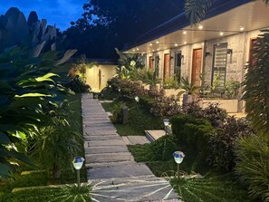 A well-lit pathway leading to a building with a stone facade and multiple doors. - Ohhana Lofts El Nido (El Nido)