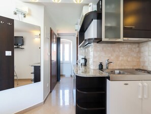 Una cocina moderna con horno integrado, cafetera y lavaplatos.