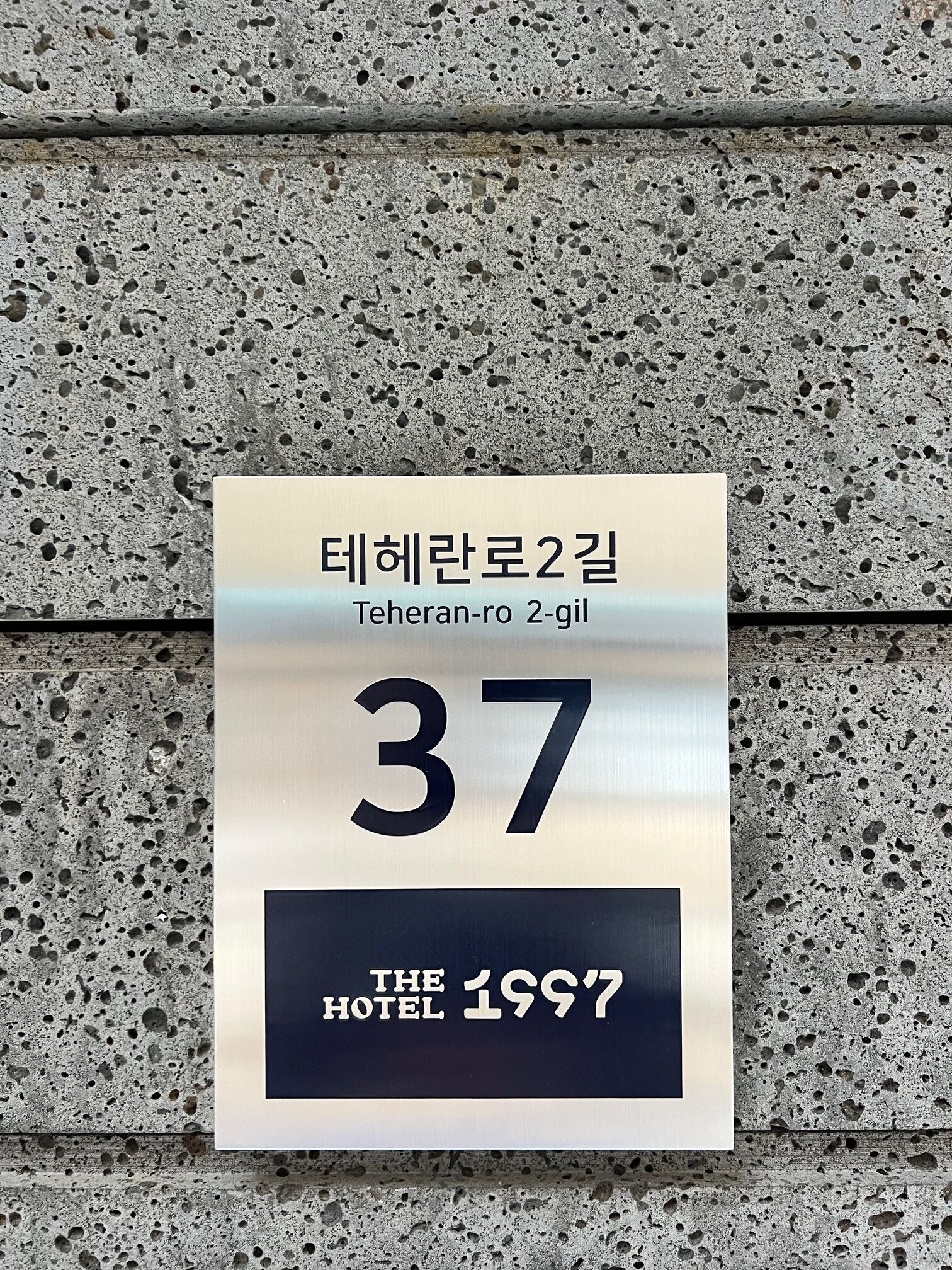A hotel sign with Korean text and the number 37, indicating room number 37.