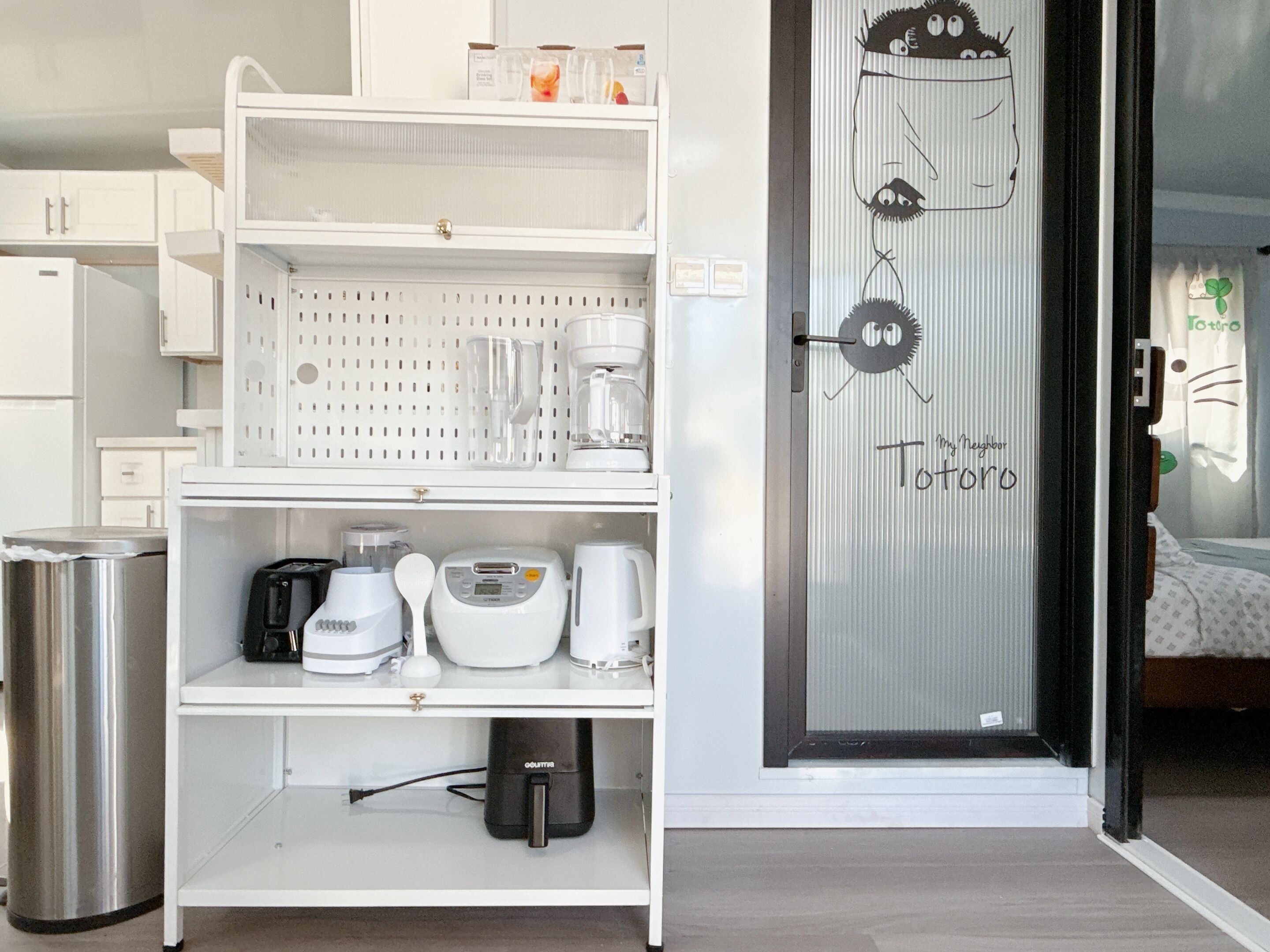 Una kitchenette equipada con cafetera, tostadora y un pequeño bote de basura.