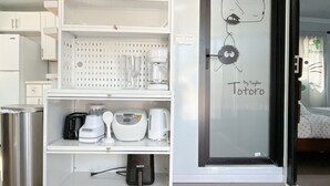 A kitchenette with a coffee maker, toaster, and a small trash bin. - Cute Totoro theme Tiny House (Rowland Heights)