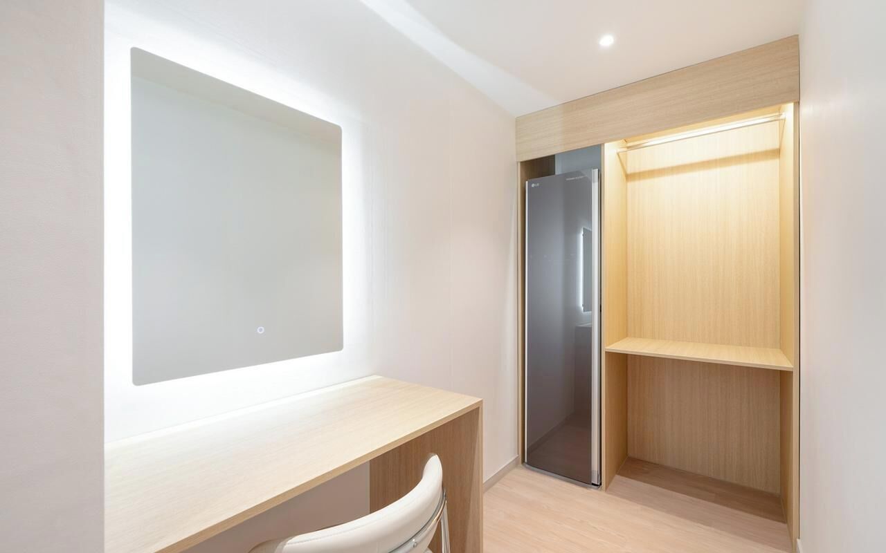 Un bagno moderno con un ampio specchio, doccia integrata e mobile lavabo in legno.