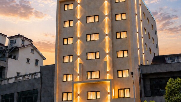 Un hôtel doté d’une façade moderne, de nombreuses fenêtres et d’une enseigne indiquant qu’il s’agit d’un hôtel.