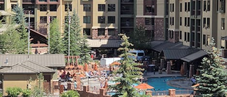 A hotel with multiple buildings, a swimming pool, and a landscaped area with trees and rocks.