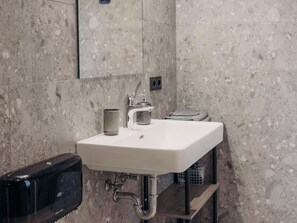 Ein Badezimmer mit Waschbecken, Spiegel und Handtuchhalter.