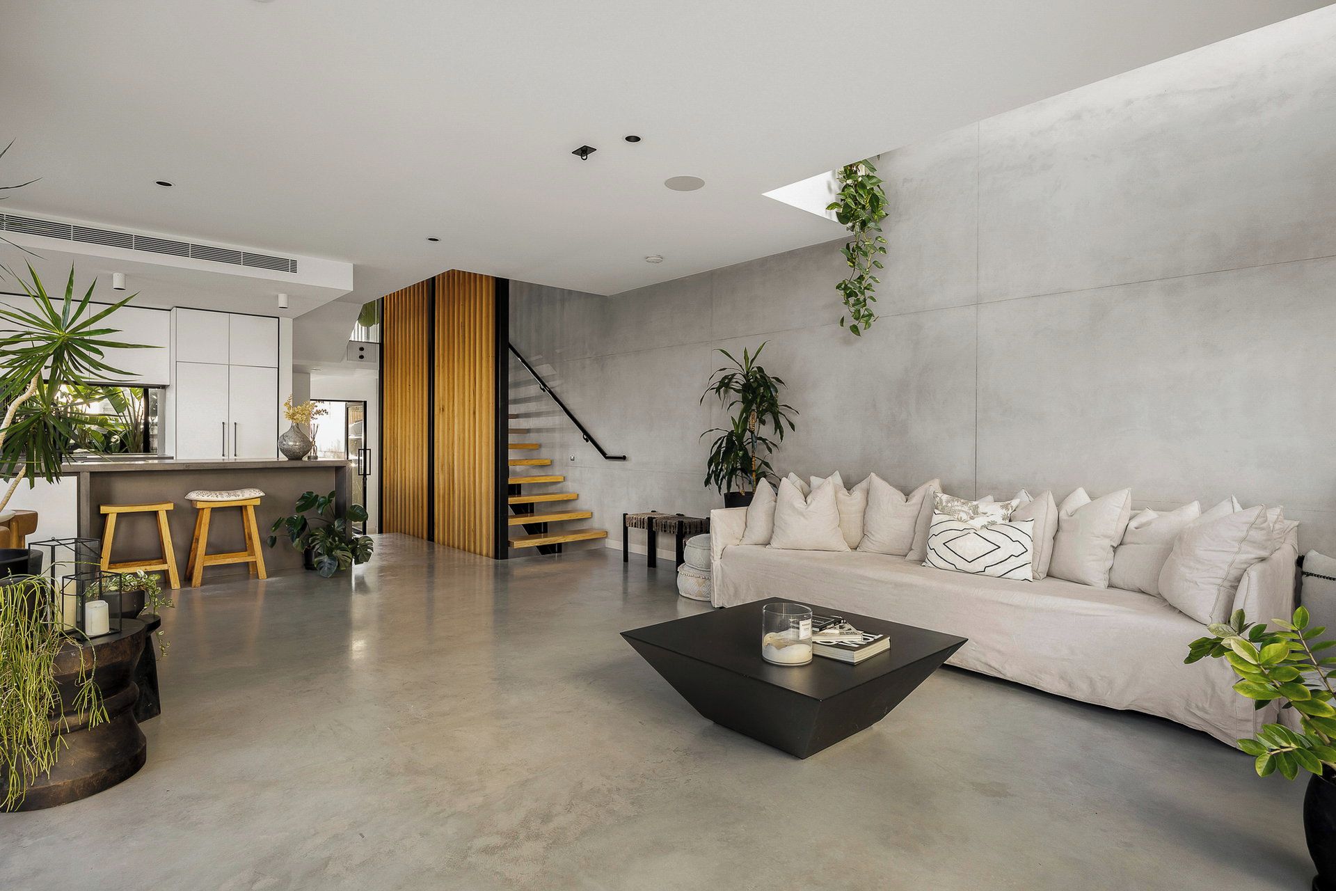 A modern living space with a sofa, coffee table, and plants.