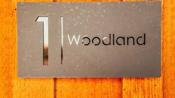 Une plaque métallique portant le chiffre « 1 » et le mot « Woodland », le tout sur un fond en bois.