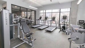 A gym with treadmills, a stationary bike, and a weight bench. - Cozy Studio Apt 1.5 Miles to Mercedes Benz Stadium (Atlanta)
