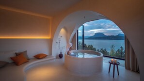 A modern spa room with a hot tub, a sofa, and a view of a lake. - lugu Lake Cheman Ruyingsong Mid Hotel (Lijiang)