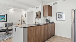Uma cozinha moderna com uma ilha central, armários de madeira e eletrodomésticos de aço inoxidável.