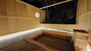 A wooden sauna with a bench, a circular window, and a bench with a bench cover.